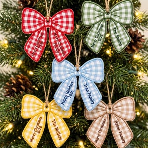 May include: Five bow-shaped Christmas ornaments with a gingham pattern in red, green, light blue, yellow, and tan. Each ornament features a jute twine hanger and is personalized with text including Merry Christmas, Happy Holidays, 2026, and family names.