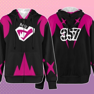 Puede incluir: Sudadera con capucha negra con cremallera y detalles en rosa y un gráfico blanco en la parte delantera que dice "PIE" con una cara de monstruo estilizada. La parte posterior de la sudadera tiene un gráfico blanco que dice "357" con detalles en rosa.