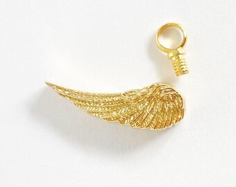 May include: Gold-toned metal angel wing charm with a loop for attaching to a necklace or bracelet. The charm is detailed with a textured feather design.