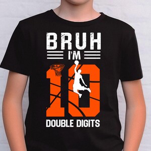May include: Black t-shirt with an orange basketball graphic and the text "BRUH I'M 10 DOUBLE DIGITS".