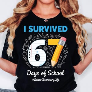 May include: Black t-shirt with the text "I Survived 67 Days of School" in blue and white. The number 67 is designed with school-themed graphics and a yellow pencil. The phrase "Days of School" is below the number, and the hashtag "#SchoolSecretaryLife" is at the bottom.