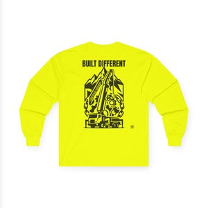 May include: A neon yellow long-sleeve shirt featuring a black graphic on the back. The design depicts a concrete pump truck, mountains, and gears, with the text BUILT DIFFERENT printed in bold black capital letters above the illustration.