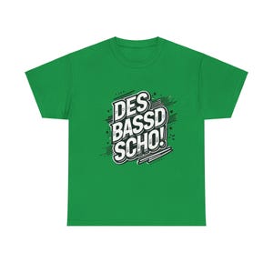 May include: Green t-shirt with a white graphic that says "DES BASSD SCHO!" in a bold, comic book style font.