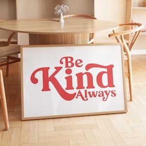 Puede incluir: Una impresión enmarcada con fondo blanco y texto rojo que dice "Be Kind Always".