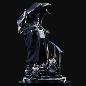 Può includere: Una statuetta di pinguino con un cappello a cilindro nero e uno smoking bianco e nero, che tiene un bicchiere di liquido. La statuetta è in piedi su una base con due piccole statuette di pinguino. Il pinguino più grande tiene un ombrello.