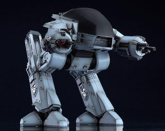 Puede incluir: Un robot articulado blanco y negro con una cabeza negra y un arma en cada brazo. El robot está de pie sobre una superficie negra.