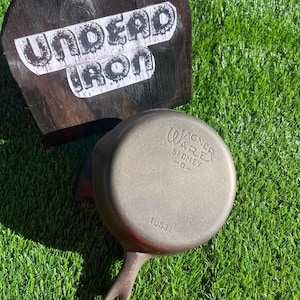 May include: A cast iron skillet with a black handle. The skillet is marked with "Wagner Ware Sydney -O- 10531".