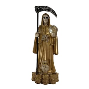 May include: A gold-colored statue of a skeletal figure in a hooded robe, holding a scythe and a crystal ball. An owl sits at the base of the statue, which is atop stacks of coins. The scythe has a black and silver decorative design.