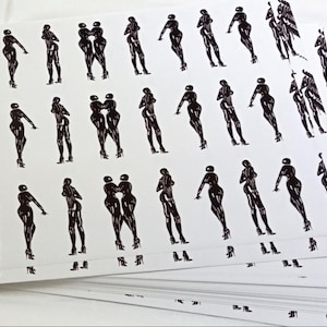 May include: A stack of white cards with a repeating black illustration of a woman in high heels. Some cards show two women embracing. The cards are stacked on a white surface.