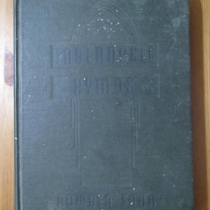 May include: A dark green hardcover book with the title "Church Music Hymns" and the text "Jubilee Edition,  Edited by Dr. W.H. Doane" on the front cover.