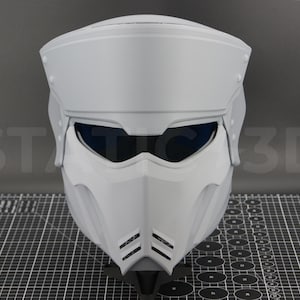 May include: White helmet with a visor and a futuristic design. The helmet has a smooth, matte finish and a dark blue visor.