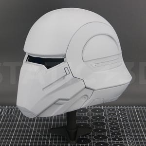 May include: A white helmet with a futuristic design. The helmet has a visor and a smooth, rounded top.