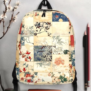 以下が含まれることがあります： 赤、青、クリーム色の花柄と植物柄のパッチワークデザインのバックパック。 バックパックには黒いストラップと上部のハンドルが付いています。 小さな茶色の革のケースと2本の鉛筆がバックパックの隣にあります。