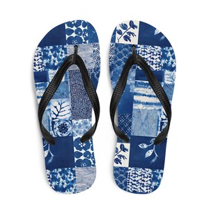 May include: A pair of flip-flops featuring a patchwork design of various blue and white patterns, including floral motifs, geometric lines, and botanical elements. The footwear has black rubber thong straps attached to the patterned footbeds.