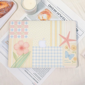 Peut inclure: Housse d'ordinateur portable avec un motif patchwork. Elle présente une fleur d'hibiscus rose, une étoile de mer et un papillon. L'étui a une palette de couleurs claires avec des nuances pastel de rose, de bleu et de jaune. Le logo Apple est visible.