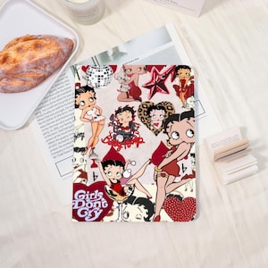 May include: A decorative tablet case featuring a collage of Betty Boop illustrations in various poses. The design includes images of Betty Boop in red, white, and black, with hearts, stars, and the text "Girls Don't Cry".
