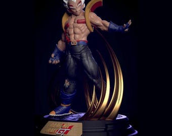 Puede incluir: Figura detallada de un personaje musculoso con cabello blanco, detalles rojos y guantes y botas azules. La figura está posada dinámicamente con un efecto de energía dorada detrás. La base tiene el texto "Dragon Ball GT".