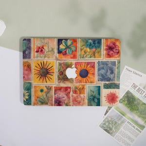 May include: A laptop skin featuring a collage of floral postage stamp designs in various colors. The design includes a sunflower, a blue flower, and a red flower. The Apple logo is visible in the center.