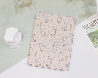 May include: A pink leather case with a repeating pattern of brown bears and leaves. The case is designed for an e-reader.