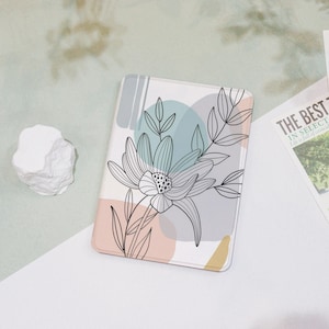 May include: A white background with a pink, blue, and gray abstract floral design. The design features a large flower with a black outline and a smaller flower with a black outline. The background is a light gray color.