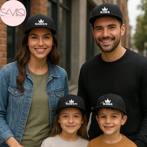 Könnte beinhalten: Vier schwarze Baseballkappen mit weiß gestickten Kronensymbolen und Text. Zwei Kappen zeigen die Wörter QUEEN und KING, während die zwei kleineren Kappen die Wörter MINI QUEEN und MINI KING tragen, alle mit strukturiertem Schirm.