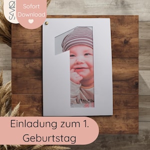 May include: A white photo frame in the shape of the number one, displaying a baby's photo. The frame is mounted on a wooden background. The image includes the text "Einladung zum 1. Geburtstag."