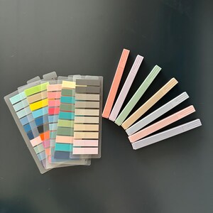 Puede incluir: Un conjunto de notas adhesivas de colores con una variedad de colores, incluyendo azul, verde, amarillo, rosa y naranja. Las notas est&aacute;n dispuestas en forma de abanico y est&aacute;n acompa&ntilde;adas de ocho resaltadores de color pastel.
