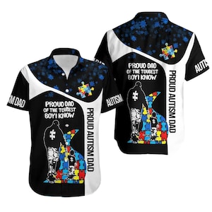 May include: Short-sleeved button-down shirt with a black and white design. The shirt features the text "PROUD DAD OF THE TOUGHEST BOY I KNOW" and "PROUD AUTISM DAD". A puzzle piece graphic is also visible.