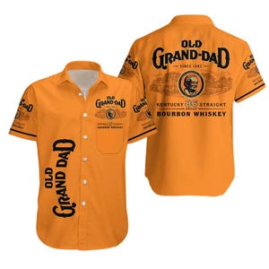 May include: Orange button-down shirt with short sleeves. The shirt features the text "OLD GRAND-DAD" in black, along with a circular logo and the words "KENTUCKY 86 STRAIGHT PROOF BOURBON WHISKEY". The shirt's design is repeated on the back.