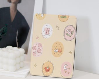 May include: A small, rectangular, cream-coloured box with a decorative design. The box features a repeating pattern of pastel pink, yellow, and white circles with various illustrations of bunnies, flowers, and stars. The box is ideal for storing small items.
