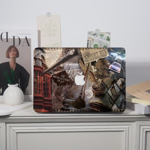 May include: A laptop with a decorative cover featuring a collage of images and text. The design includes elements like a quill, a broom, a golden snitch, and the text "Knight Bus" and "The Marauders Map". The Apple logo is visible.