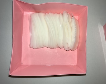 Op de afbeelding: Een roze doos met een stapel witte, halfronde, zelfklevende wimperstickers.