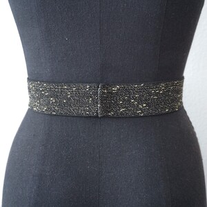 May include: A black elastic belt with gold glitter woven into the fabric.