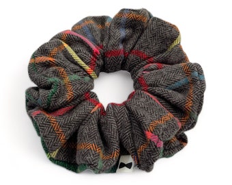 May include: A brown and orange plaid scrunchie with a herringbone pattern.