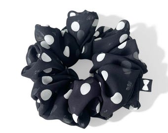 May include: Black and white polka dot hair scrunchie made of soft fabric.