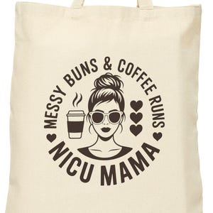 Puede incluir: Bolso tote de color crema con el texto "Messy Buns & Coffee Runs NICU Mama" en un diseño circular. El diseño incluye una mujer con gafas de sol, una taza de café y corazones. El bolso es sostenido por una persona.