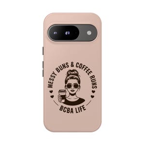 Puede incluir: Funda de teléfono rosa claro con un gráfico en blanco y negro de una mujer con gafas de sol sosteniendo una taza de café. El texto dice "Messy Buns & Coffee Runs" y "BCBA Life" en un diseño circular.