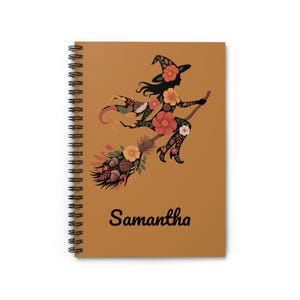 May include: Spiral-bound notebook with a brown cover featuring a floral witch silhouette riding a broom. The witch and broom are decorated with orange, yellow, and white flowers. The name "Samantha" is printed in black script.
