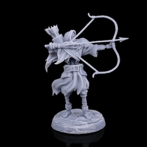 Puede incluir: Figura gris de un arquero con una capa con capucha, tensando un arco. La figura está sobre una base circular, con un carcaj de flechas en la espalda. El arco está tenso, listo para disparar. El fondo es negro.
