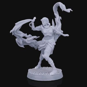 Puede incluir: Figura gris claro de una guerrera en una pose dinámica, con tela fluida y detalles de armadura. La figura se encuentra sobre una base circular, con los brazos extendidos, con una capa dramática y fluida. El diseño general sugiere un tema de fantasía.