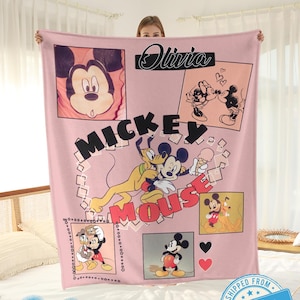 May include: A pink Mickey Mouse blanket featuring various images of Mickey and Minnie Mouse, Pluto, and the text "Mickey Mouse". The blanket includes the text "Olivia" and "Custom name".