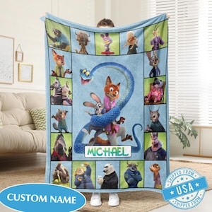 May include: A light blue fleece blanket featuring characters from a cartoon movie. The blanket has a central image of a fox and a rabbit, with a blue snake wrapped around them. The blanket has the text "MICHAEL" and "CUSTOM NAME".