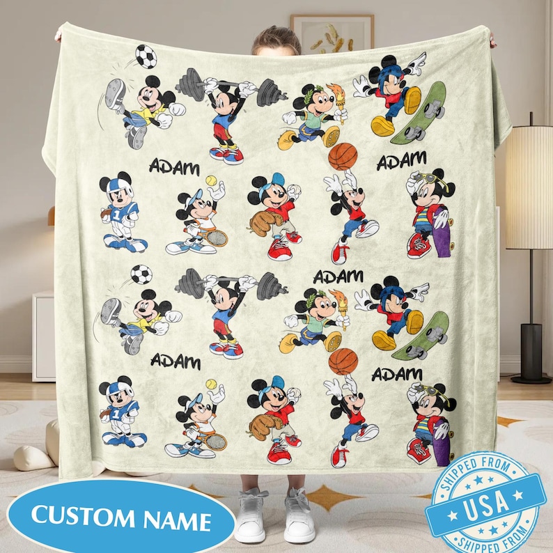 Puede incluir: Una manta de color crema con im&aacute;genes de dibujos animados de Mickey Mouse practicando varios deportes, como f&uacute;tbol, ​​halterofilia, b&eacute;isbol, baloncesto y skateboarding. El nombre "ADAM" est&aacute; impreso debajo de algunas de las im&aacute;genes. La manta tiene el texto "CUSTOM NAME" y un sello "SHIPPED FROM USA".