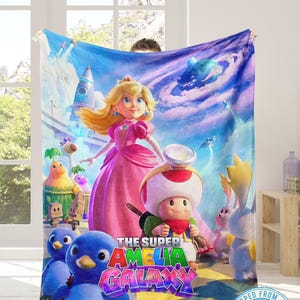 K&ouml;nnte beinhalten: Eine wei&szlig;e Keramik-Tasse mit schwarzem Henkel und dem Text "But First, Coffee" in fetter, schwarzer Schrift. Die Tasse steht vor einem verschwommenen Hintergrund, der eine gem&uuml;tliche Umgebung suggeriert. Die Tasse ist etwa 10 cm hoch.