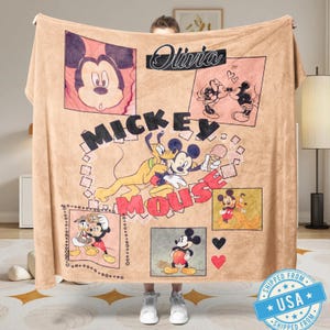 May include: A tan blanket featuring Mickey Mouse and Pluto illustrations in various poses. The blanket has the name "Olivia" in cursive and the words "Mickey Mouse" in large letters. The blanket has a vintage style.