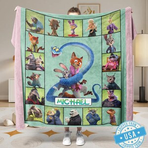 May include: A personalized fleece blanket featuring characters from the animated movie Zootopia. The blanket has a light green center with character portraits and a large blue snake design. The name "MICHAEL" is displayed on the blanket.