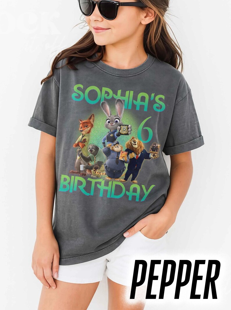 May include: Dark gray t-shirt featuring characters from the movie Zootopia, with the text "Sophia's 6th Birthday". The design includes Judy Hopps, Nick Wilde, and other characters. The word "Pepper" is printed at the bottom.