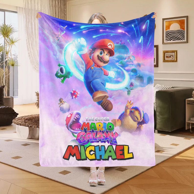 May include: A white ceramic mug with a black handle and the text "But First, Coffee" in a bold, black font. The mug is set against a blurred background, highlighting its clean design.