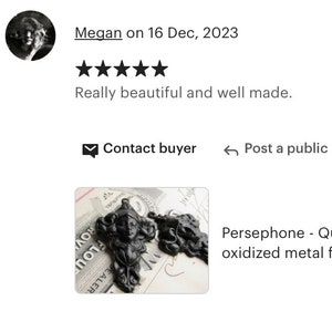 May include: Two black oxidized metal figures of a woman's head with long hair and a crown. The figures are on a piece of paper with writing on it. The text on the paper reads "Persephone - Queen of the Underworld".