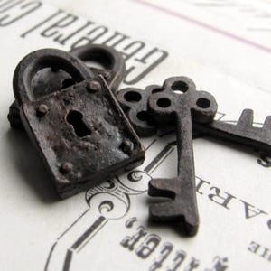 May include: Close-up of antique-style, rusty metal lock and keys. The lock is square with a keyhole and rivets. Two keys are next to the lock. The objects are on a vintage paper background with faded text.